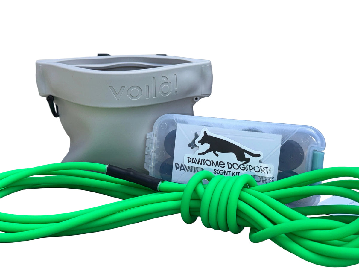 Dog treat pouch, small scent kit, and rolled biothane long line on white background.