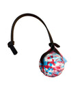 A small round ball with a red, white, and blue abstract pattern, attached to a black strap on a white background.