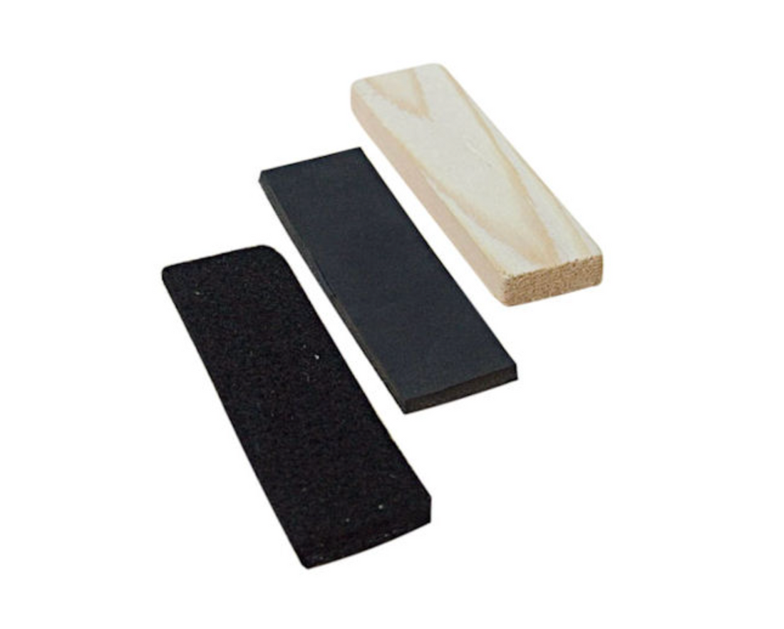 Three rectangular tracking articles on a white background: two black foam blocks and one wooden block.