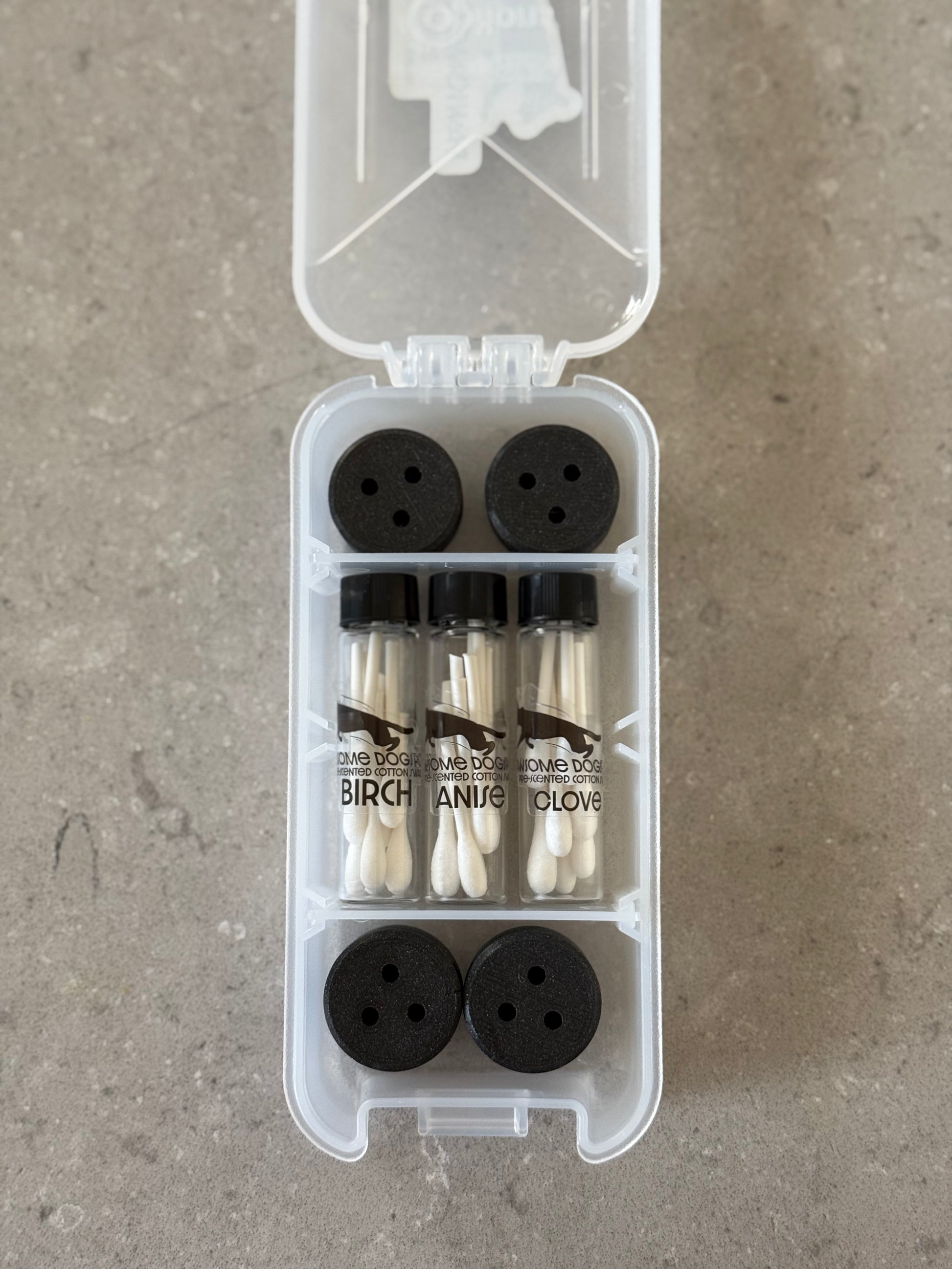 The image shows a Basic Nosework Kit by Pawsome DogSports, including a white kit box, pre-cut scented swabs in tubes, and galaxy black magnetic mini-hides for dogs' scent detection training.