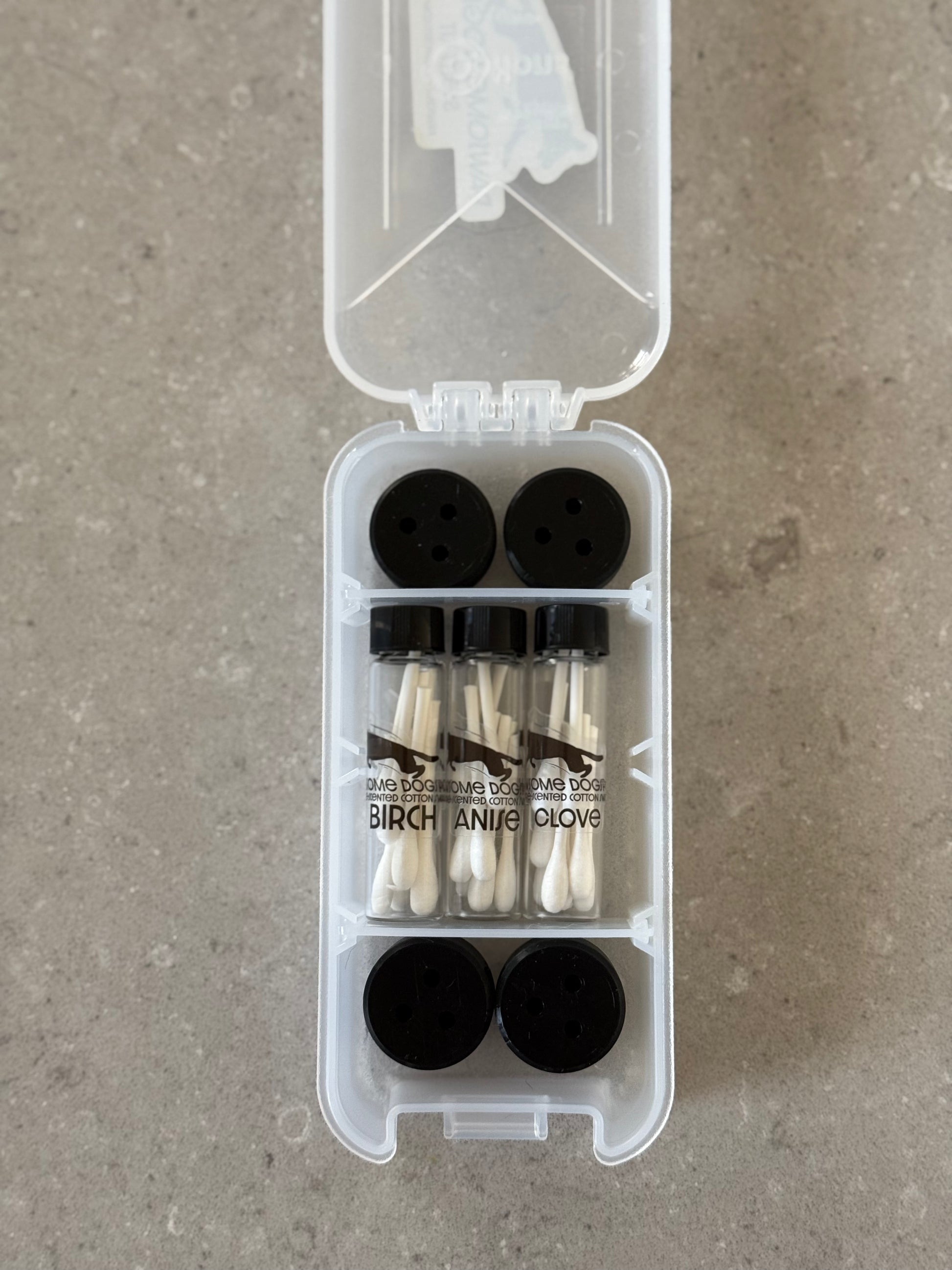 The image shows a Basic Nosework Kit by Pawsome DogSports, including a white kit box, pre-cut scented swabs in tubes, and jet black magnetic mini-hides for dogs' scent detection training.