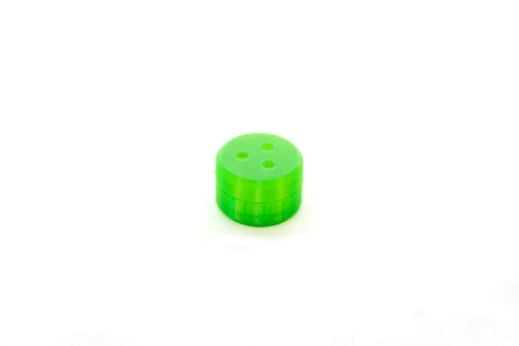A green mini magnetic hide vessel with three perforations designed for scent detection training exercises for dogs.