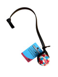 A foam ball dog toy with a black strap and a colorful red, white, and blue patterned ball with a white background. 
