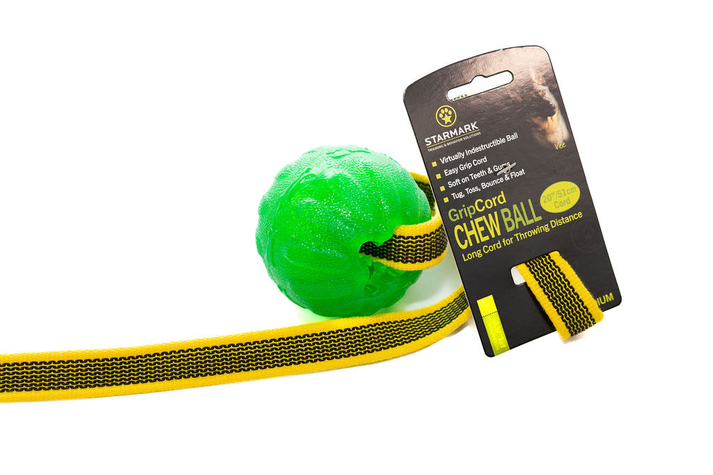 A green rubber chew ball with a yellow GripCord attached, displayed with its packaging that reads 'GripCord Chew Ball'.