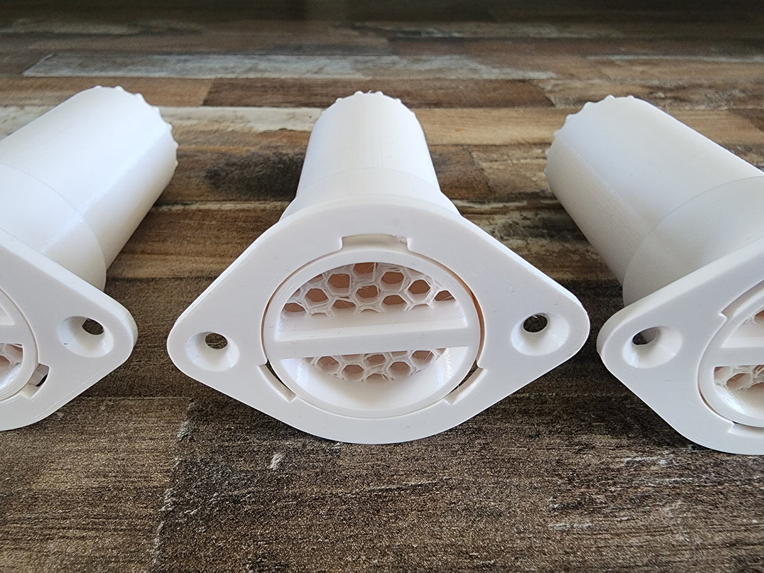 A set of white PETG scent detection tubes sitting on a wooden structure.
