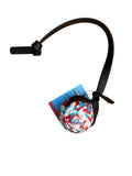 A black strap with a small round multicolor patterned ball attached on a white background.